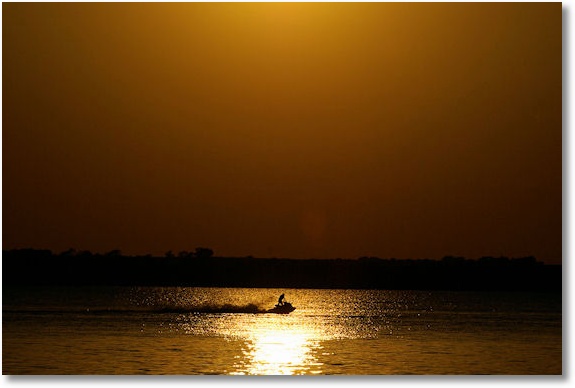 jet ski on Lake Canton in glare of setting sun, Oklahoma