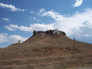 House and yard atop a barren hill