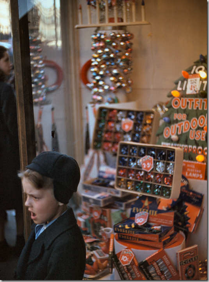 Boy beside store window display of Christmas ornaments Boy beside store window display of Christmas ornaments